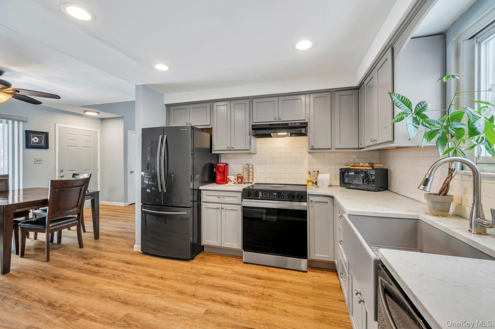 17 Groton Lane Coram, NY 11727 - Photo 18 of 34 a kitchen with a refrigerator a stove a sink cabinets and a dining table