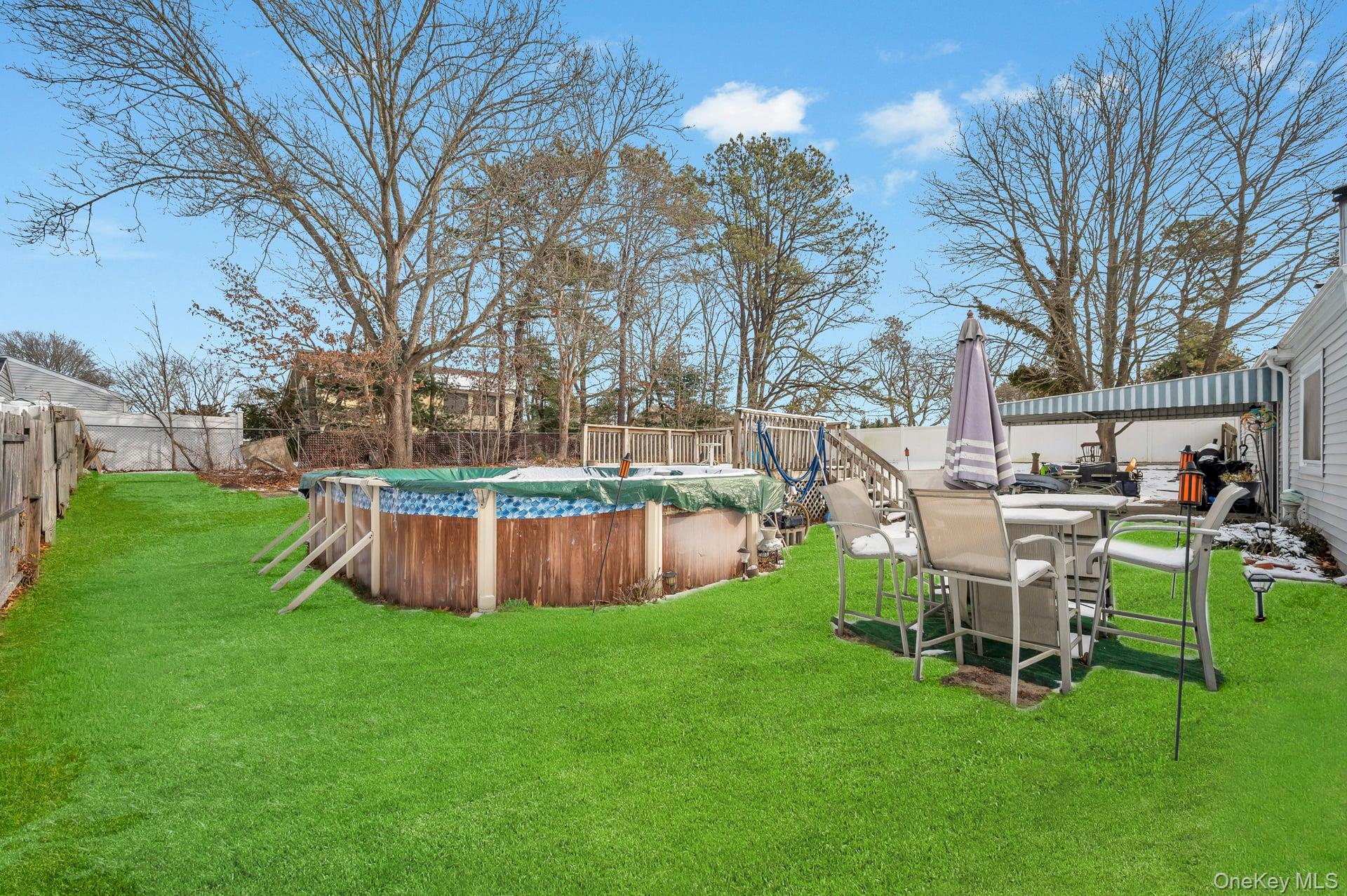 17 Groton Lane Coram, NY 11727 - Photo 31 of 34 a view of a swimming pool with lawn chairs and a big yard