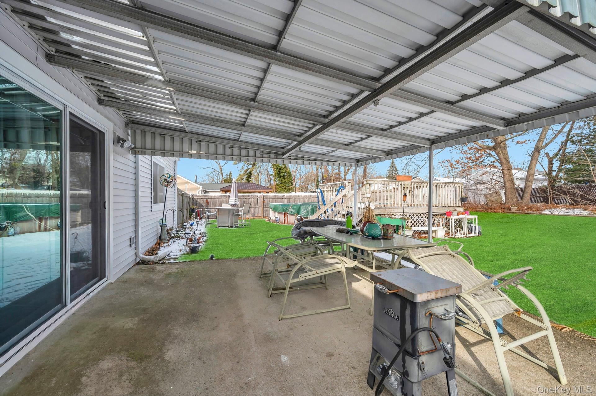 17 Groton Lane Coram, NY 11727 - Photo 34 of 34 a view of a patio with table and chairs next to a yard