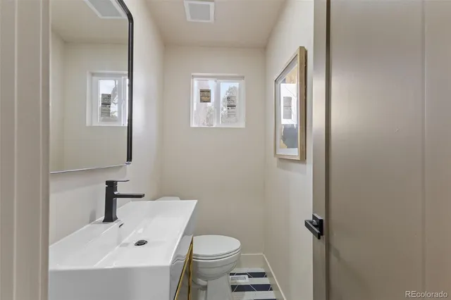 a bathroom with a sink toilet and a mirror