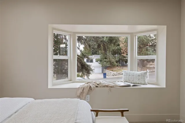 a room with a large window and a bed