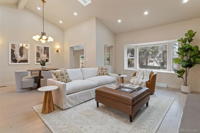 a living room with furniture potted plant and a large window