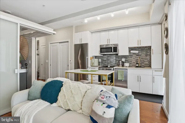 a kitchen with stainless steel appliances kitchen island granite countertop a refrigerator and cabinets