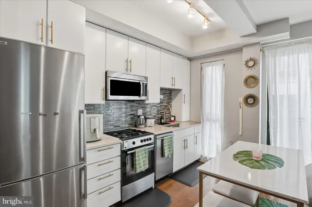 a kitchen with stainless steel appliances a refrigerator stove and microwave
