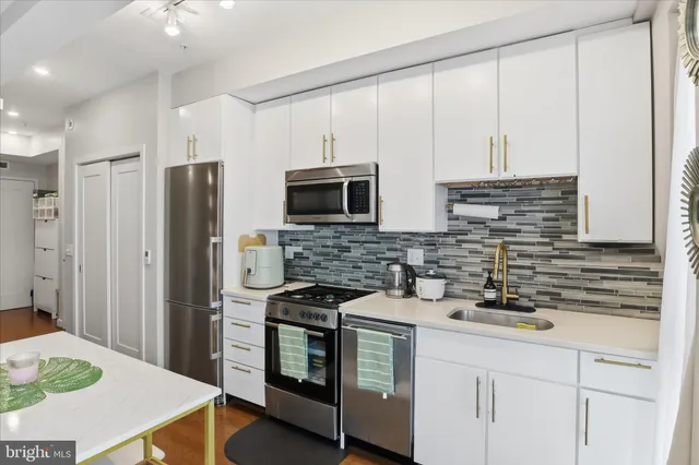 a kitchen with stainless steel appliances a stove microwave and refrigerator