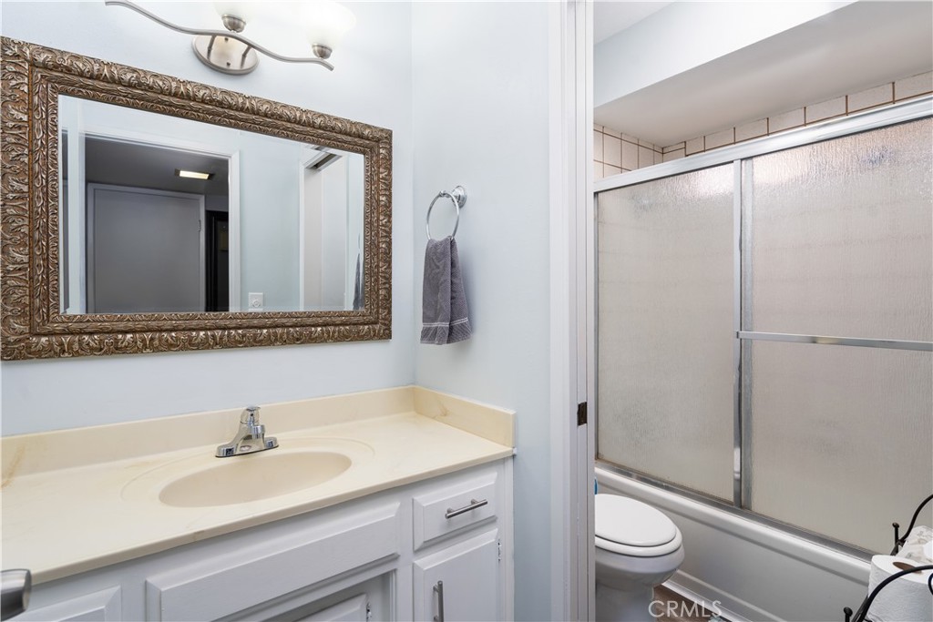 1000 Olive Drive, Unit 40 Bakersfield, CA 93308 - Photo 7 of 16 a bathroom with a granite countertop sink mirror and a toilet