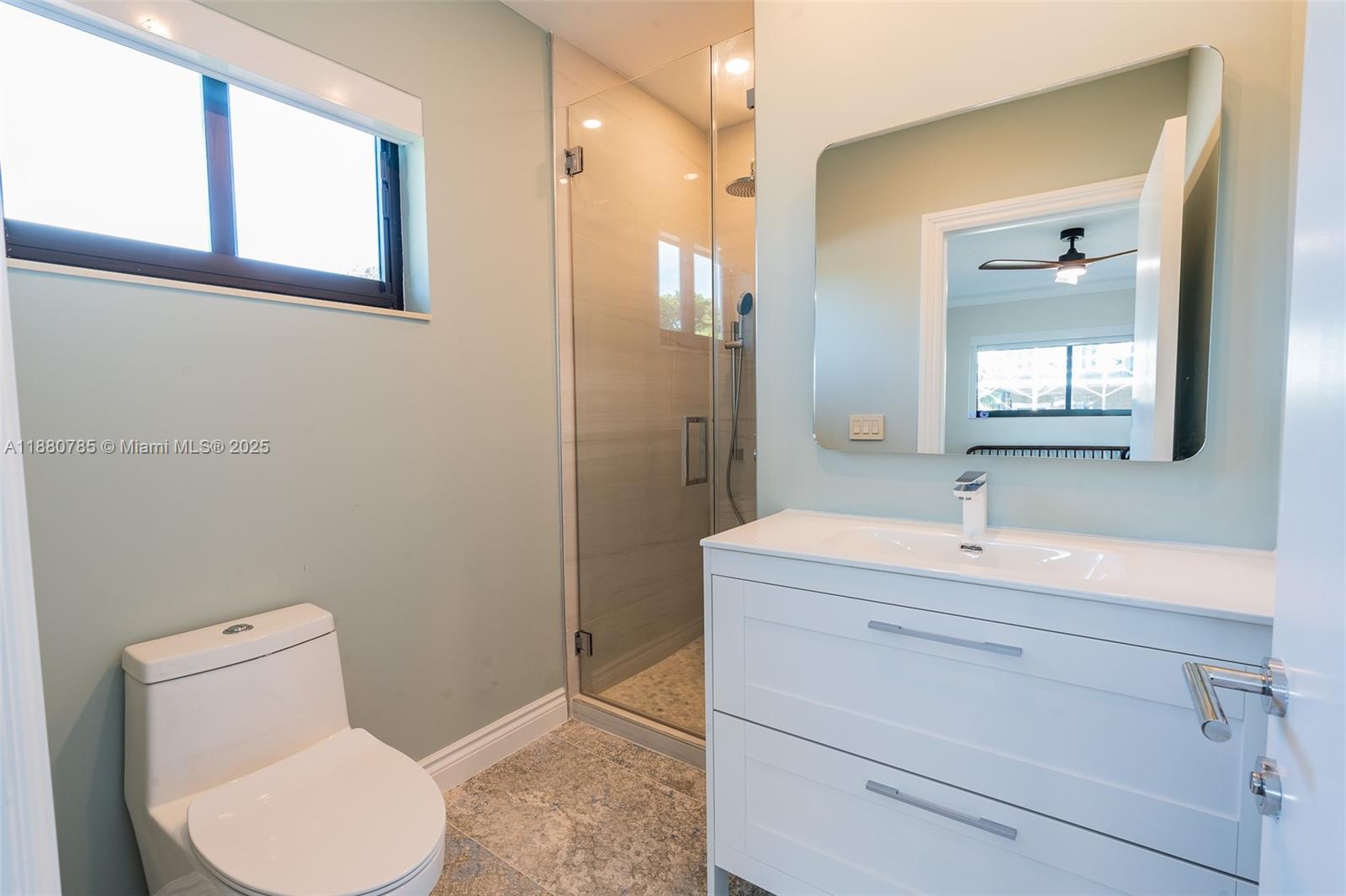 12905 Cherry Road North Miami, FL 33181 - Photo 17 of 22 a bathroom with a toilet sink vanity and mirror