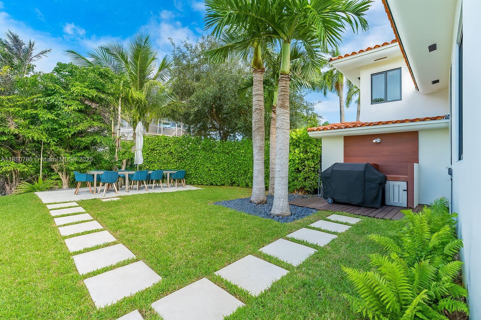 12905 Cherry Road North Miami, FL 33181 - Photo 20 of 22 a view of a backyard with couches plants and large trees