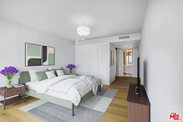 a bedroom with a bed and a chandelier