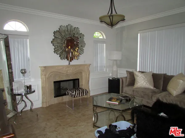 a living room with furniture a fireplace and a chandelier
