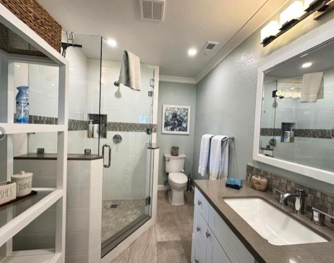 1 La Playa Street Monterey, CA 93940 - Photo 11 of 17 a bathroom with a granite countertop sink a toilet a mirror and shower