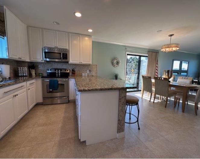 1 La Playa Street Monterey, CA 93940 - Photo 7 of 17 a kitchen with stainless steel appliances granite countertop a stove top oven a sink a dining table and chairs