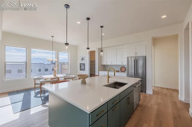 a large kitchen with kitchen island a large counter top space a sink stainless steel appliances and cabinets