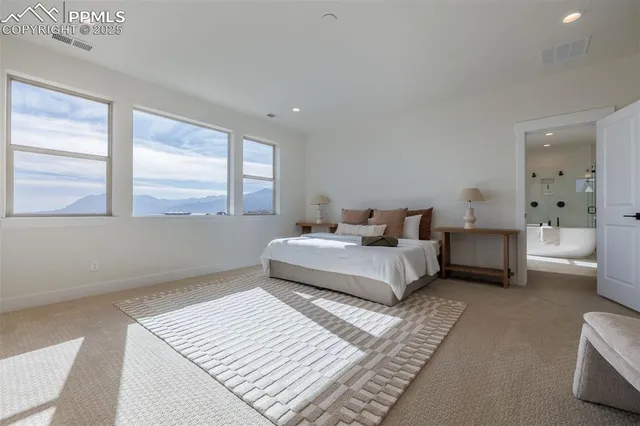 a spacious bedroom with a bed and a large window