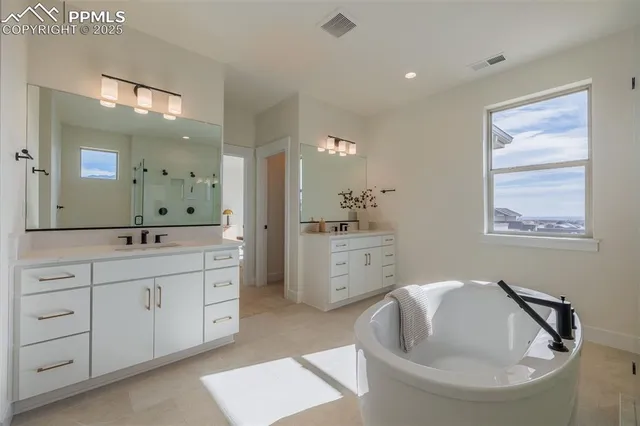 a spacious bathroom with a double vanity sink a mirror and a bathtub