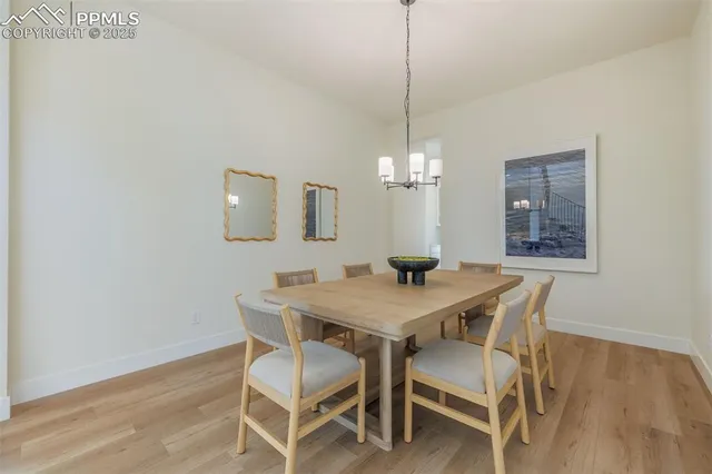 a view of a dining room with furniture a chandelier and wooden floor