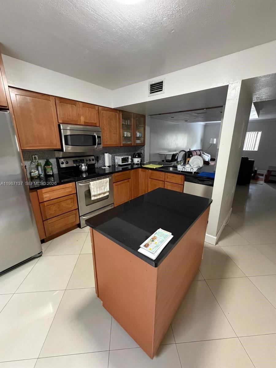 8240 Southwest 149th Court, Unit 7202 Miami, FL 33193 - Photo 2 of 11 a kitchen with stainless steel appliances granite countertop a stove and a sink