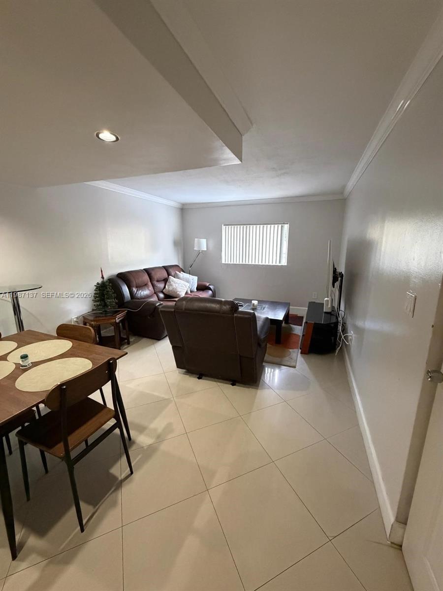 8240 Southwest 149th Court, Unit 7202 Miami, FL 33193 - Photo 4 of 11 a living room with furniture and a refrigerator