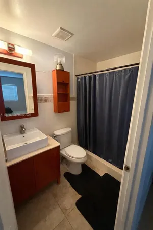 a bathroom with a toilet sink double vanity and mirror