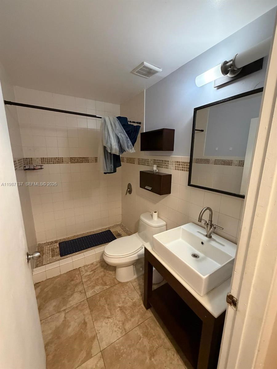 8240 Southwest 149th Court, Unit 7202 Miami, FL 33193 - Photo 10 of 11 a bathroom with a sink toilet and mirror