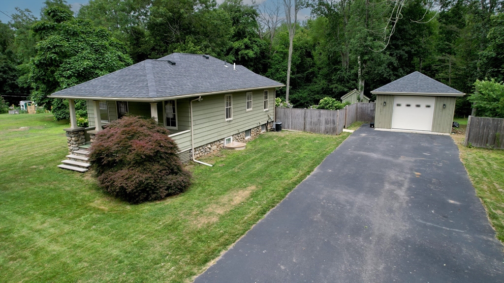 a front view of a house with a garden and trees