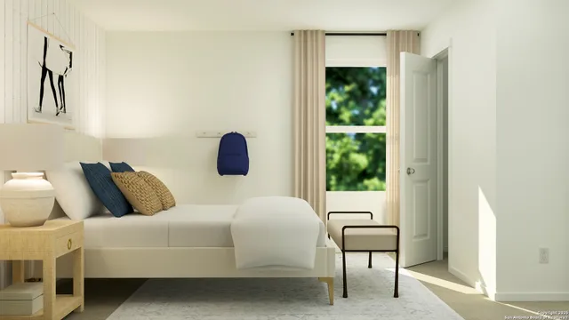 a bedroom with a bed a lamp and a large window