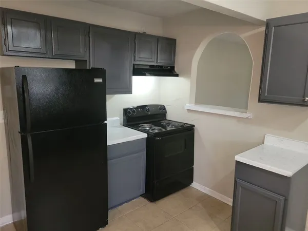 a kitchen with a refrigerator and a stove top oven
