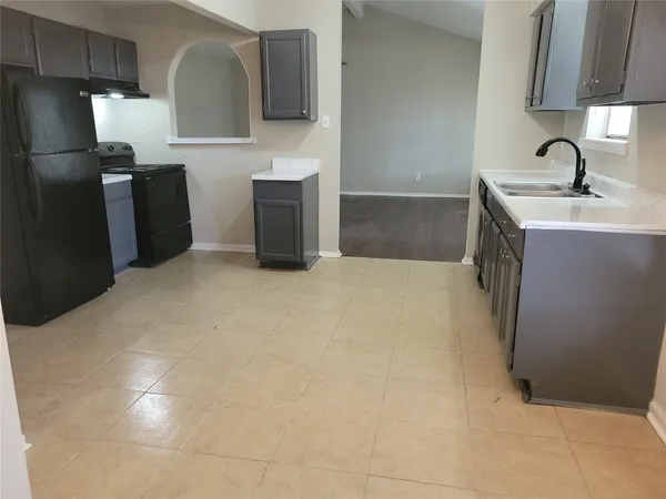 a kitchen with granite countertop a sink and a refrigerator