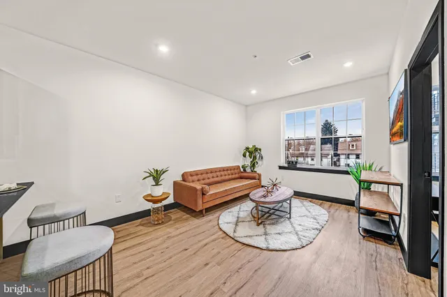 a living room with furniture and a wooden floor