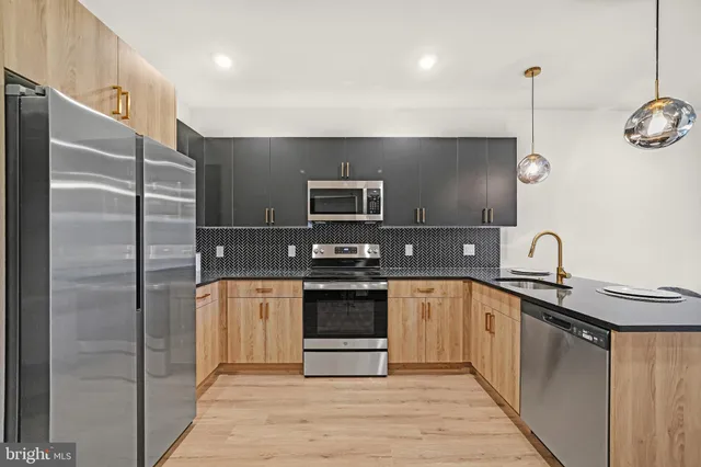a kitchen with stainless steel appliances granite countertop a sink and a refrigerator