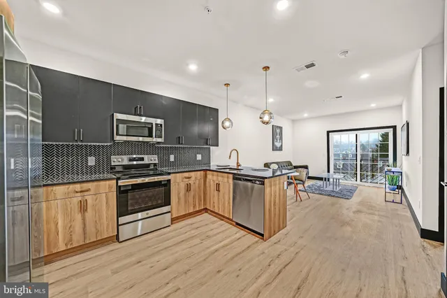 a large kitchen with granite countertop a stove top oven a sink a counter space and cabinets