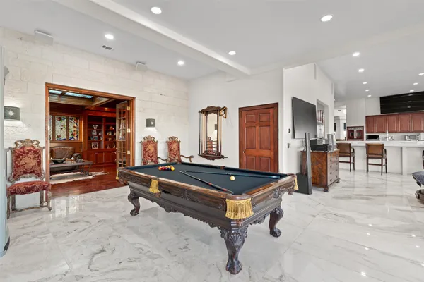 a living room with stainless steel appliances lots of furniture and kitchen view