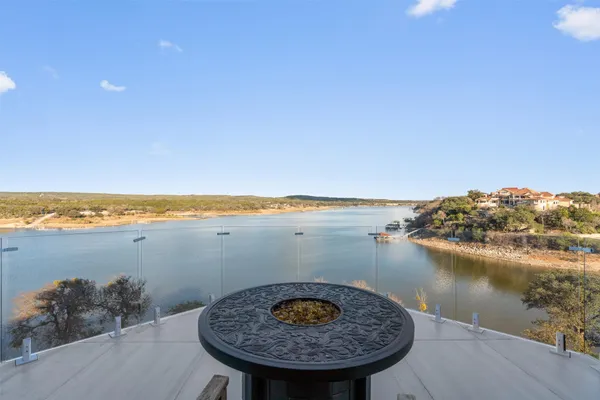a view of a lake with a table and a chair with wooden floor
