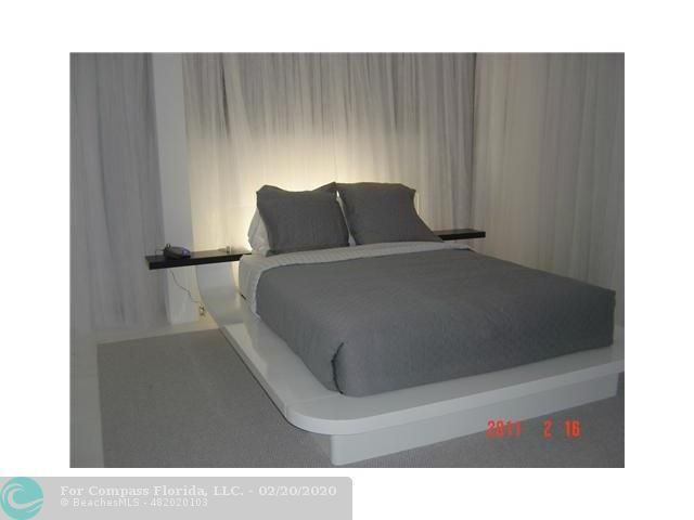 a large white kitchen with lots of counter top space and living room