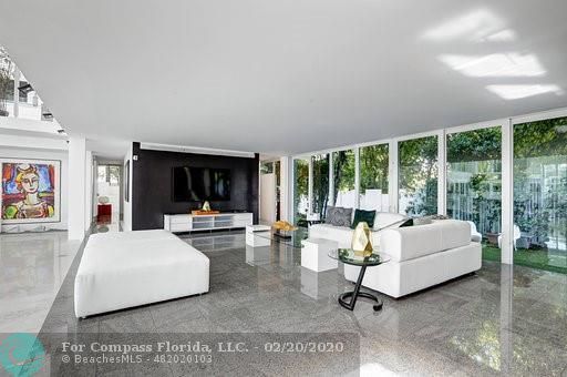 a living room with furniture fireplace and a large window