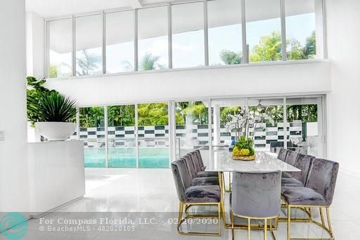 a view of a patio with couches table and chairs with palm trees