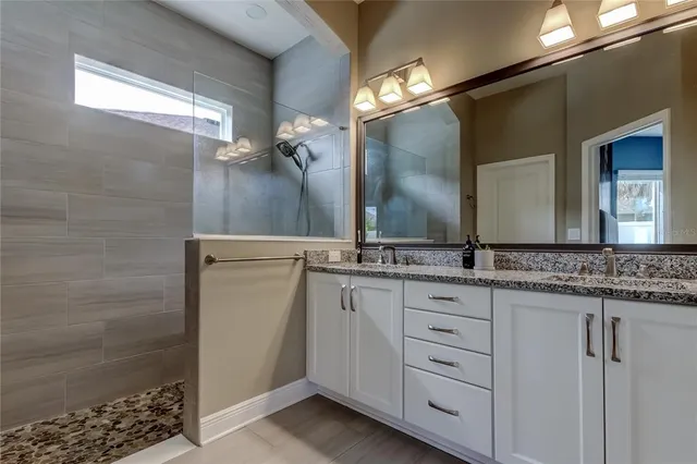a bathroom with a granite countertop sink and a mirror