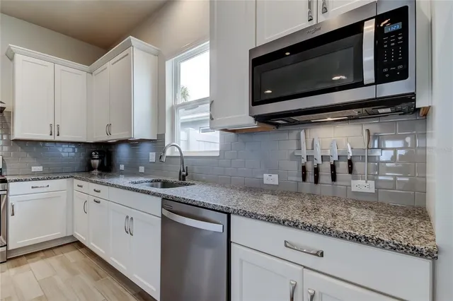 a kitchen with stainless steel appliances granite countertop a refrigerator and a stove top oven