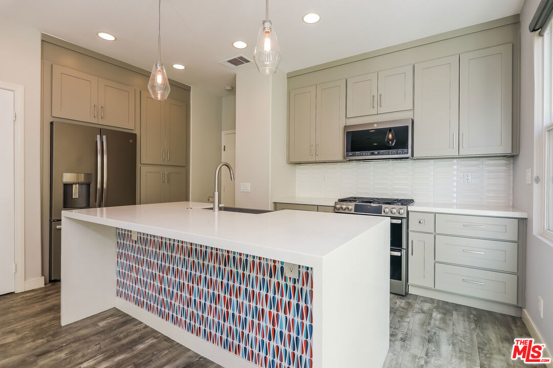 3 Wood Barn Road Ladera Ranch, CA 92694 - Photo 2 of 27 a kitchen with kitchen island a sink stainless steel appliances and cabinets