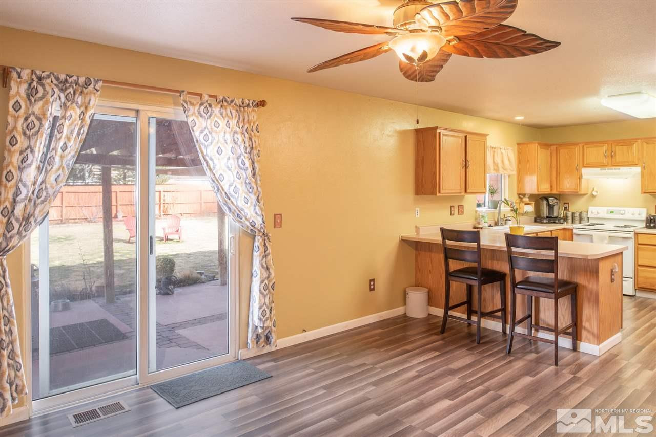 18205 Fontana Court Reno, NV 89508 - Photo 12 of 27 a dining room with wooden floor a chandelier a glass table and chairs