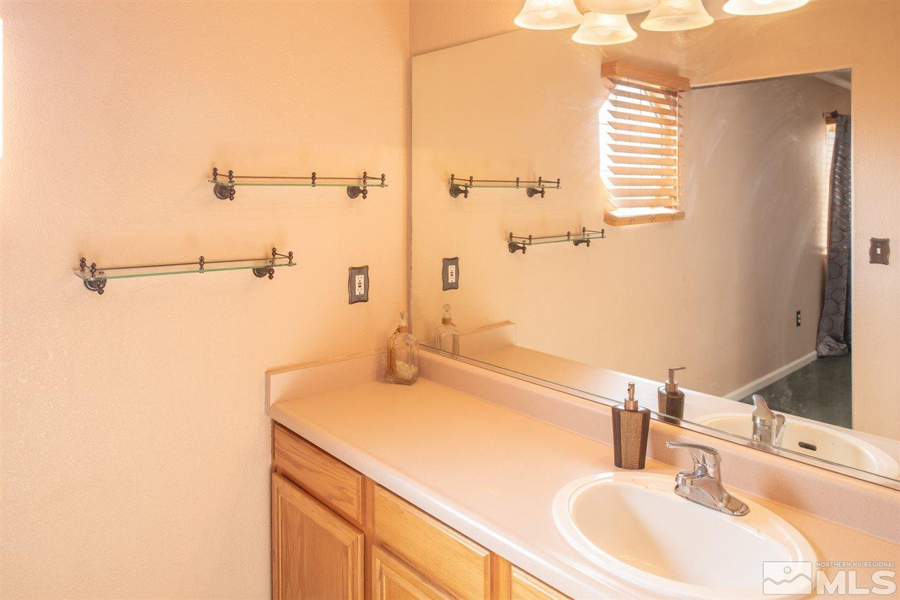 18205 Fontana Court Reno, NV 89508 - Photo 17 of 27 a bathroom with a sink and a large mirror