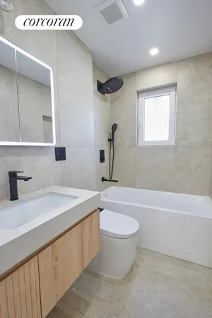 a bathroom with a granite countertop sink a toilet and bathtub