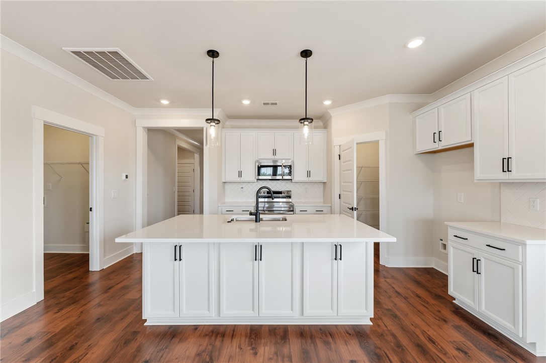 310 Bluestem Court Anderson, SC 29621 - Photo 13 of 36 This kitchen features a central island, modern appliances, and rich laminate flooring.