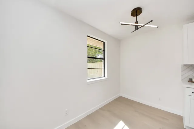 an empty room with a window and a ceiling fan