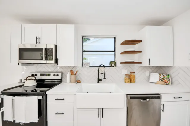 a kitchen with a sink a stove and cabinets