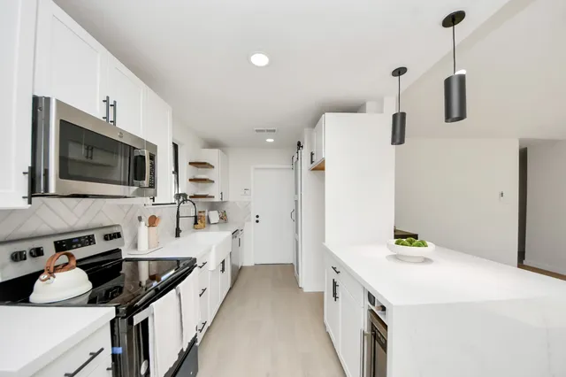 a kitchen with stainless steel appliances a stove sink microwave and cabinets