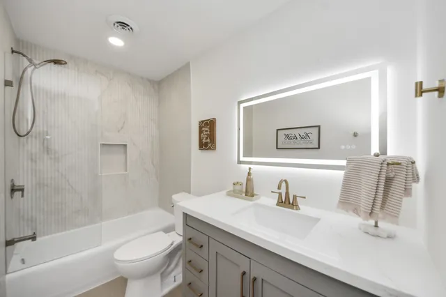 a bathroom with a sink toilet and shower