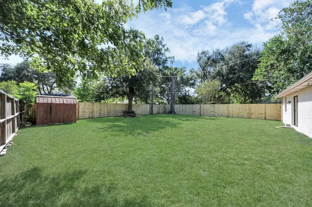 a view of a backyard with a garden and large trees