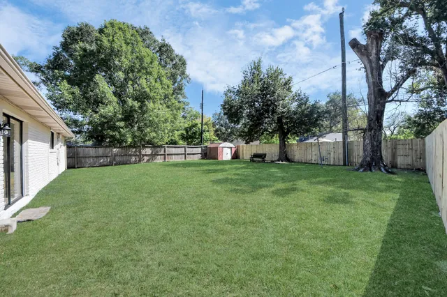 a view of a house with backyard and a tree