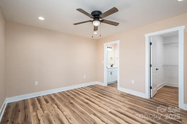a view of a bedroom with a bed and a chandelier fan